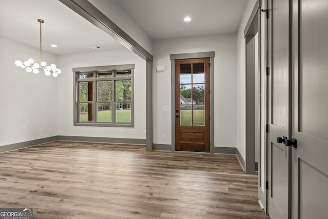 entrance foyer featuring hardwood / wood-style floors, plenty of natural light, and an inviting chandelier