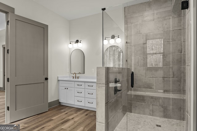 bathroom with walk in shower, hardwood / wood-style floors, and vanity