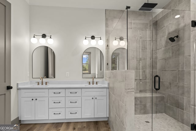 bathroom with hardwood / wood-style flooring, vanity, and walk in shower