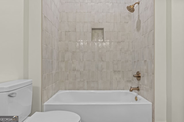 bathroom with toilet and tiled shower / bath combo