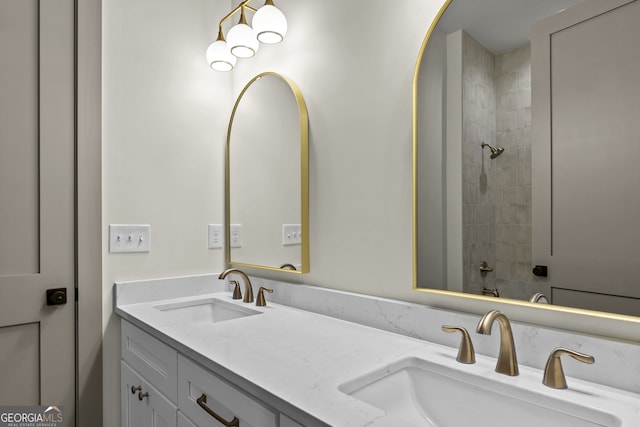 bathroom with tiled shower and vanity