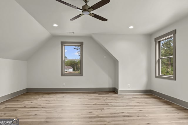 bonus room with light wood-type flooring, a wealth of natural light, vaulted ceiling, and ceiling fan