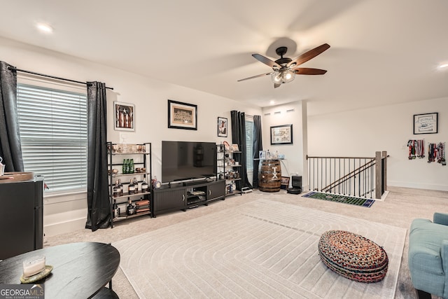 carpeted living room with ceiling fan