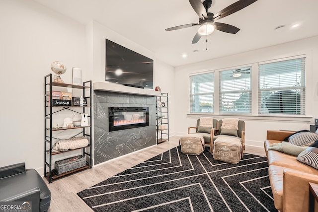 living room featuring hardwood / wood-style floors, a fireplace, and ceiling fan