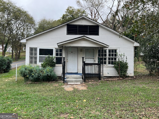 bungalow-style home with a front yard