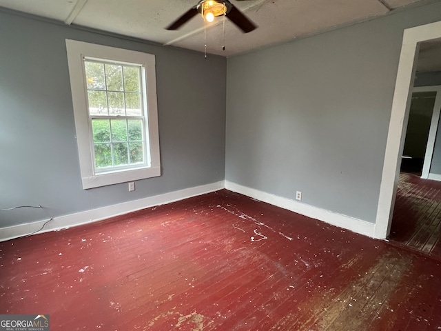 spare room with dark wood-type flooring and ceiling fan