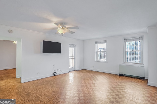 unfurnished room with radiator, ceiling fan, light parquet flooring, and crown molding