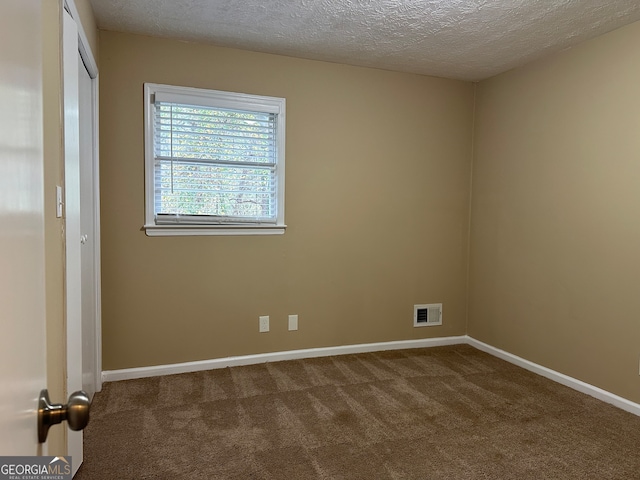 unfurnished room with a textured ceiling and carpet floors