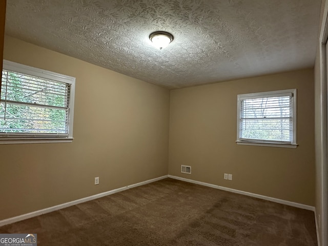 carpeted spare room featuring a textured ceiling