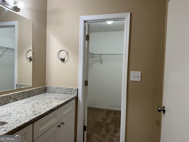 2929 Stratford Mill Rd, Lithonia, GA 30038 - bathroom featuring vanity, a spacious closet, and baseboards