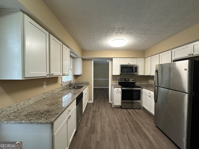 kitchen featuring dark wood-type flooring, appliances with stainless steel finishes, sink, and white cabinets