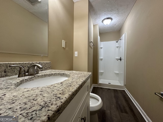 2929 Stratford Mill Rd, Lithonia, GA 30038 - bathroom featuring a stall shower, wood finished floors, a textured ceiling, baseboards, and vanity