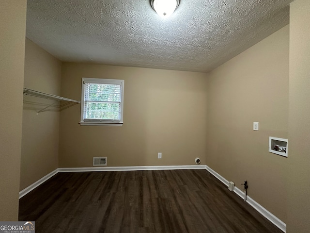 clothes washing area with washer hookup, hookup for a gas dryer, dark hardwood / wood-style floors, and a textured ceiling