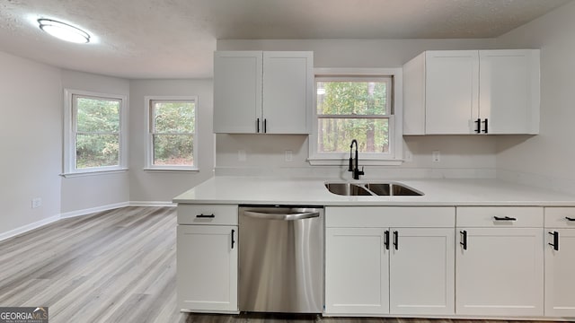 245 Southmoor Cir, Stockbridge, GA 30281 - kitchen featuring dishwasher, a sink, white cabinetry, light countertops, and plenty of natural light