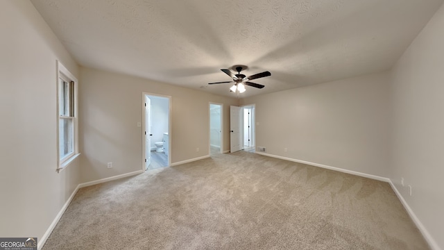 carpeted spare room featuring a textured ceiling and ceiling fan