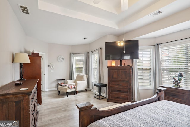 bedroom with ceiling fan, multiple windows, and light hardwood / wood-style floors