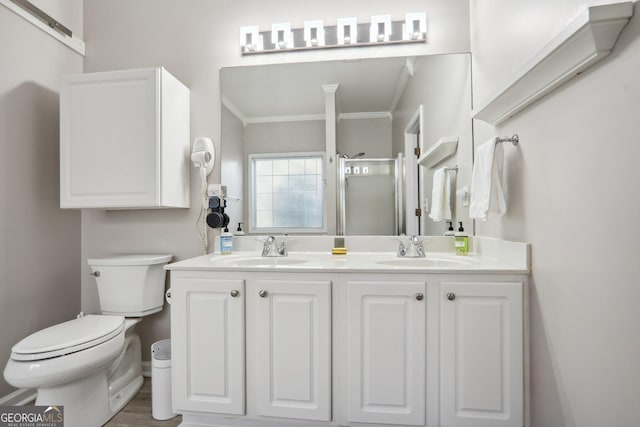 bathroom with wood-type flooring, crown molding, vanity, an enclosed shower, and toilet