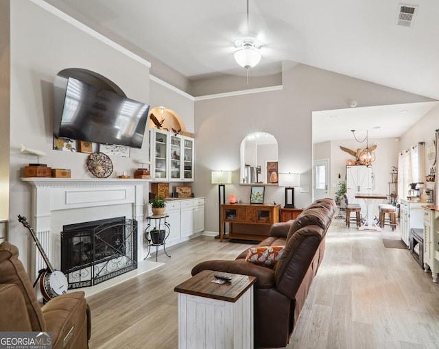 living room featuring light hardwood / wood-style floors, ceiling fan with notable chandelier, and high vaulted ceiling