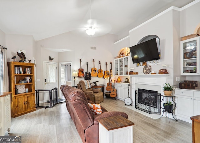 living room with ceiling fan, light hardwood / wood-style flooring, and lofted ceiling