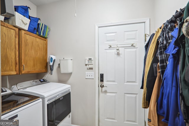 laundry room with washing machine and dryer and cabinets