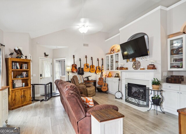 living room featuring vaulted ceiling, ceiling fan, and light hardwood / wood-style flooring