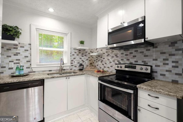 kitchen with stainless steel appliances, white cabinets, sink, and a textured ceiling