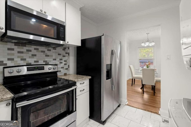 kitchen featuring stainless steel appliances, a notable chandelier, light tile patterned flooring, backsplash, and white cabinetry