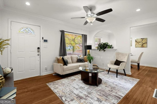 living room featuring ceiling fan, dark hardwood / wood-style floors, and ornamental molding