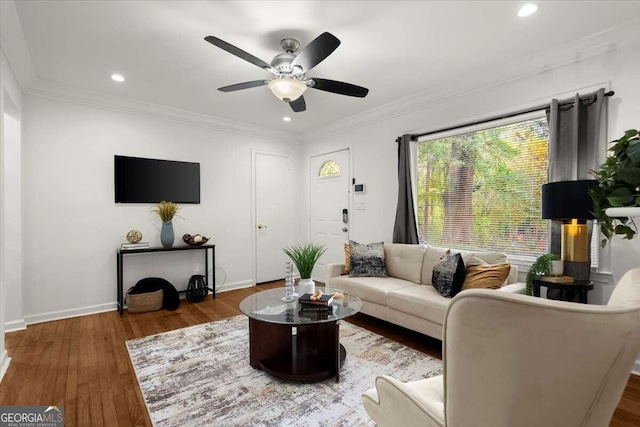 living room with ornamental molding, dark hardwood / wood-style floors, and ceiling fan