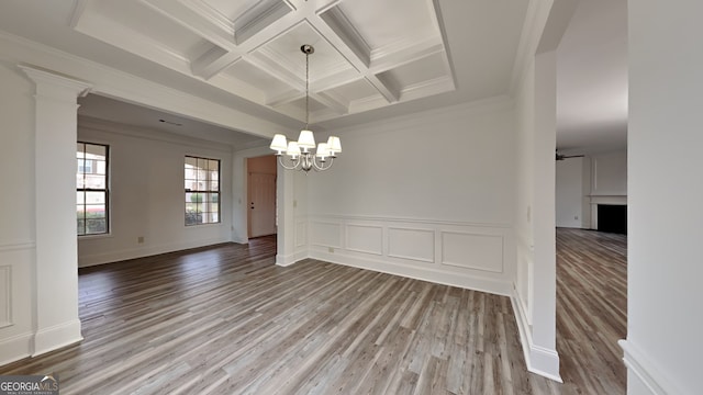 unfurnished room featuring coffered ceiling, wood-type flooring, and crown molding