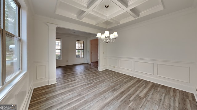 unfurnished dining area with wood-type flooring, beamed ceiling, crown molding, and decorative columns