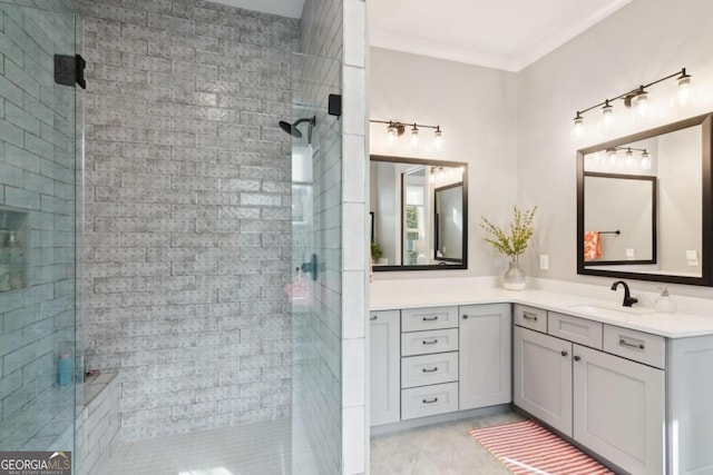 bathroom with a shower with shower door, vanity, and ornamental molding