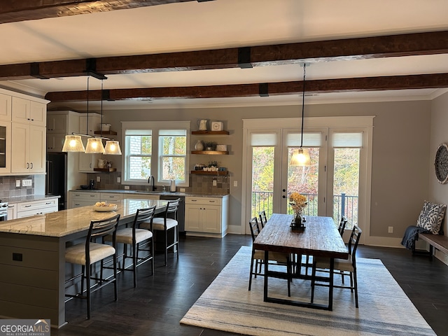 dining space with beam ceiling, sink, dark hardwood / wood-style floors, and plenty of natural light