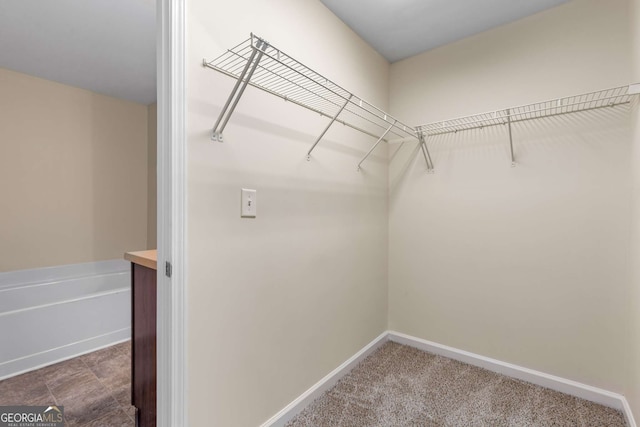 spacious closet featuring dark carpet