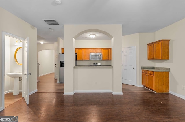 kitchen with dark wood-type flooring and appliances with stainless steel finishes