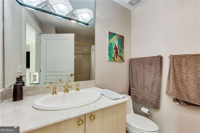 bathroom with walk in shower, vanity, and toilet