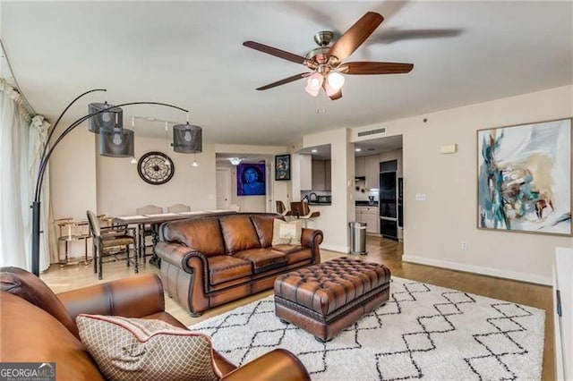 living room featuring ceiling fan and light wood-type flooring