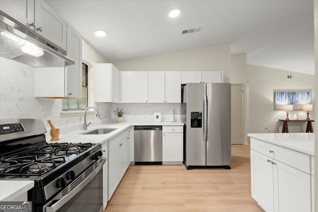 kitchen with appliances with stainless steel finishes, light hardwood / wood-style flooring, white cabinetry, and sink