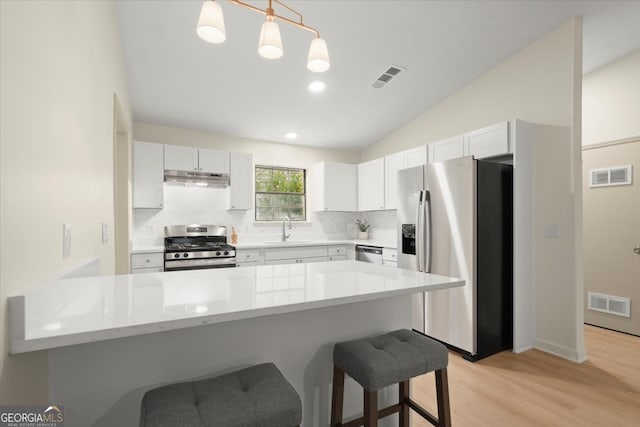 kitchen featuring pendant lighting, white cabinetry, sink, and appliances with stainless steel finishes