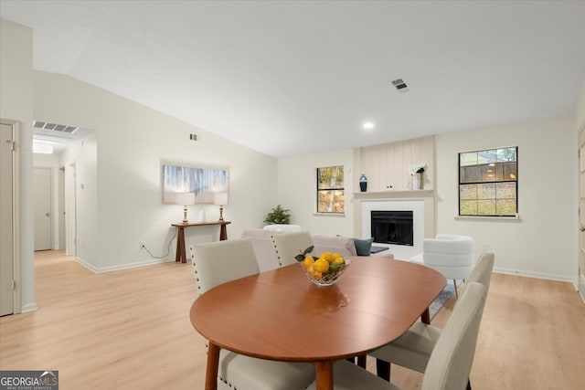 dining area with light hardwood / wood-style floors, vaulted ceiling, and a healthy amount of sunlight