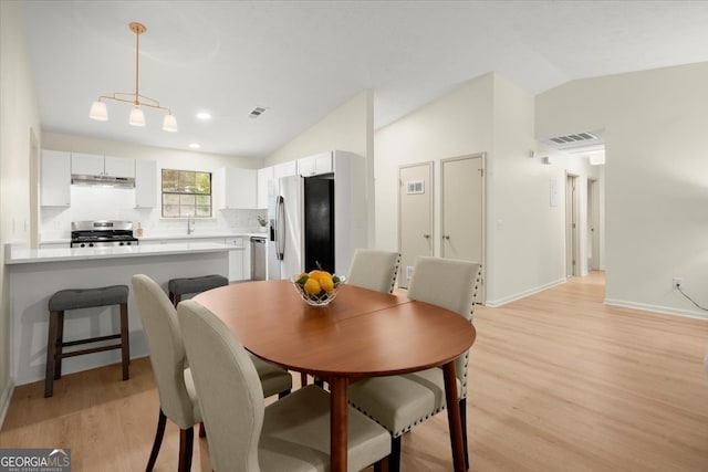 dining room featuring light hardwood / wood-style flooring and lofted ceiling