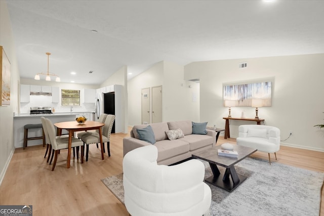 living room featuring light hardwood / wood-style floors and lofted ceiling