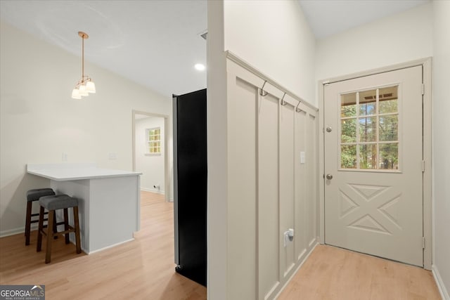 mudroom featuring light hardwood / wood-style flooring, lofted ceiling, and a notable chandelier