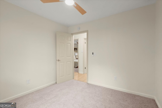 carpeted spare room featuring ceiling fan