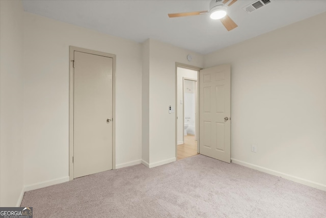 unfurnished bedroom featuring light carpet, a closet, and ceiling fan