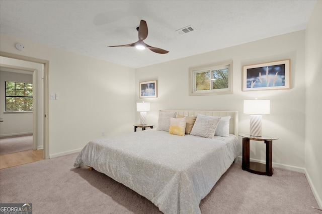 bedroom with ceiling fan and light carpet