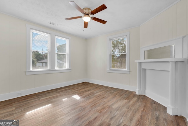 unfurnished room featuring hardwood / wood-style flooring, ceiling fan, and crown molding