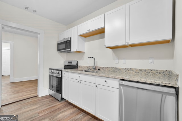 kitchen featuring stainless steel appliances, white cabinetry, light stone countertops, sink, and light hardwood / wood-style flooring