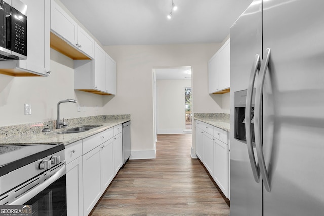 kitchen featuring stainless steel appliances, light hardwood / wood-style floors, white cabinetry, and sink