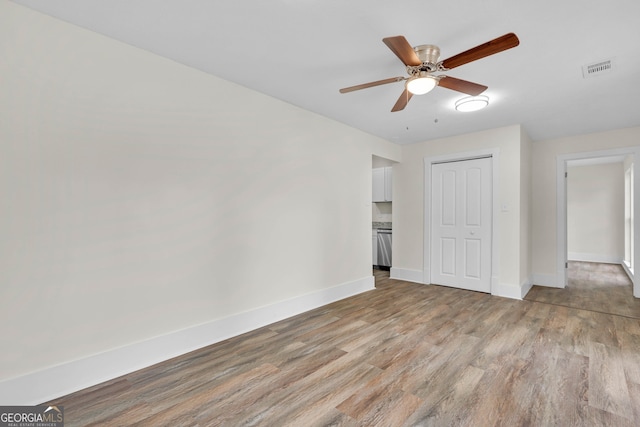 unfurnished bedroom featuring ceiling fan, a closet, and light hardwood / wood-style flooring